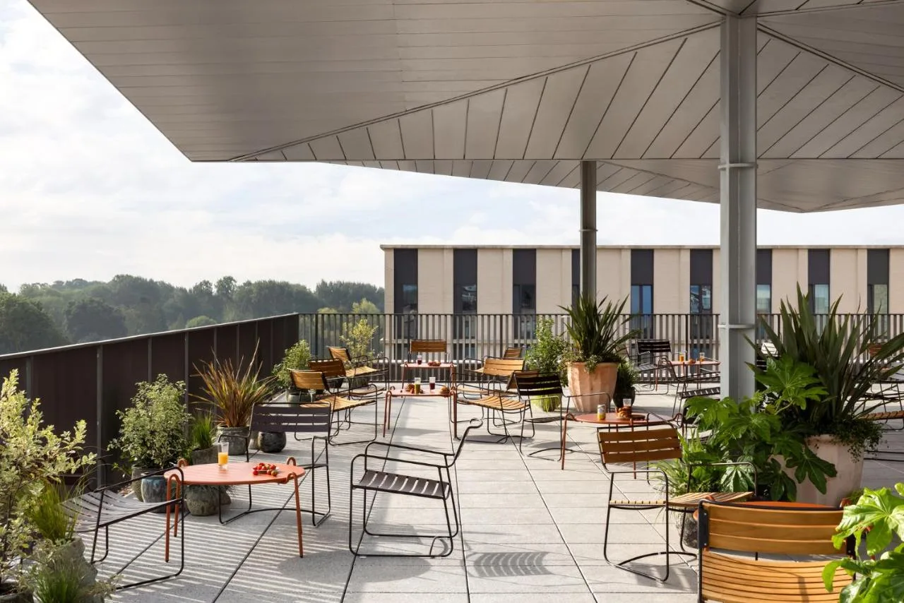 a patio with tables and chairs on a roof at Hyatt Centric Cambridge in Cambridge