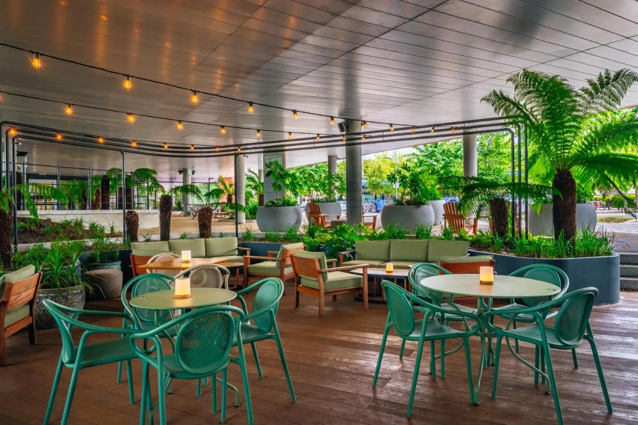an outdoor patio with tables and chairs and plants at Hyatt Centric Cambridge in Cambridge