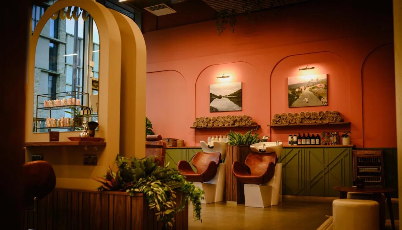 a restaurant with orange walls and chairs and a bar at Hyatt Centric Cambridge in Cambridge