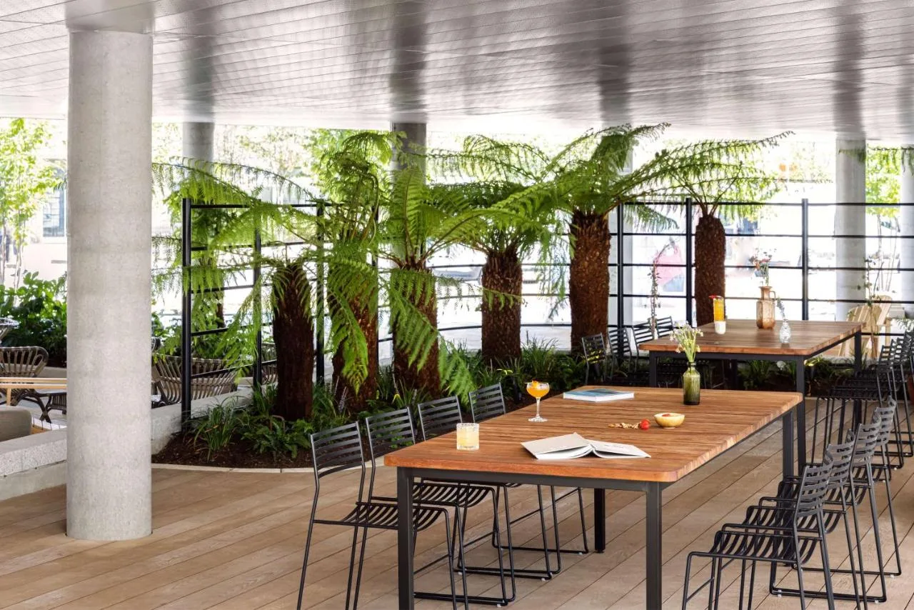 a dining room with tables and chairs and plants at Hyatt Centric Cambridge in Cambridge