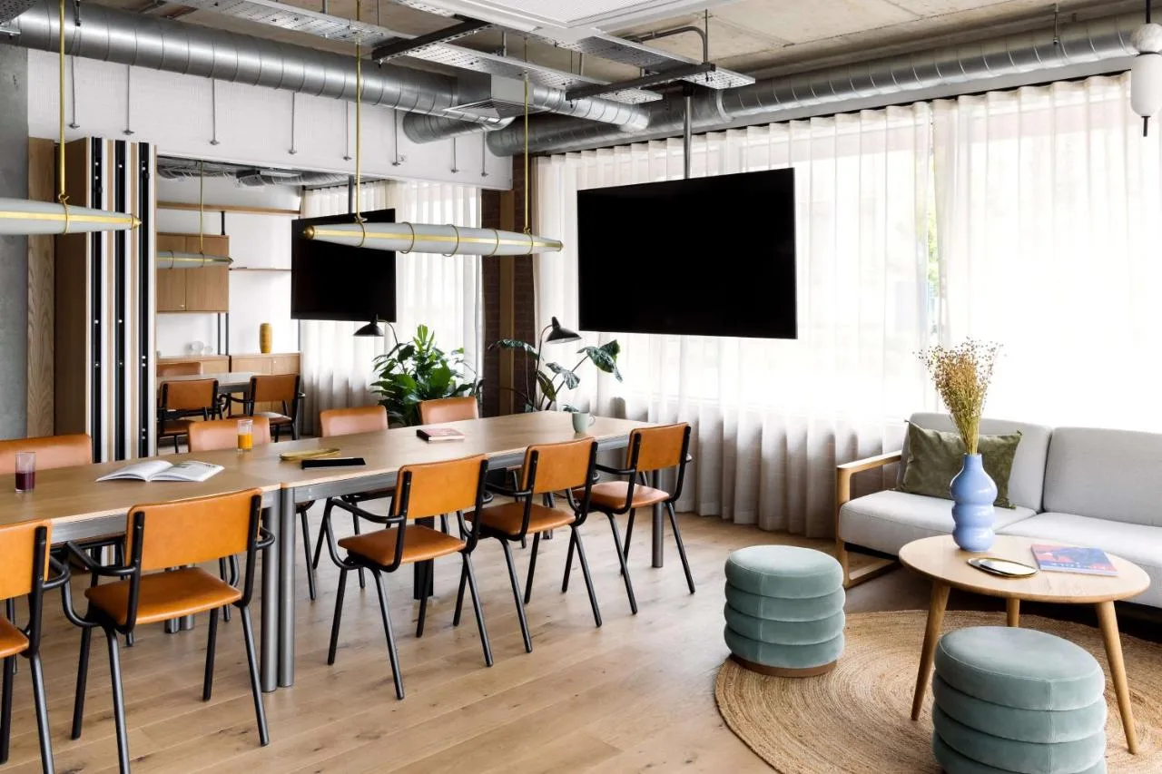 a dining room with a table and chairs and a couch at Hyatt Centric Cambridge in Cambridge